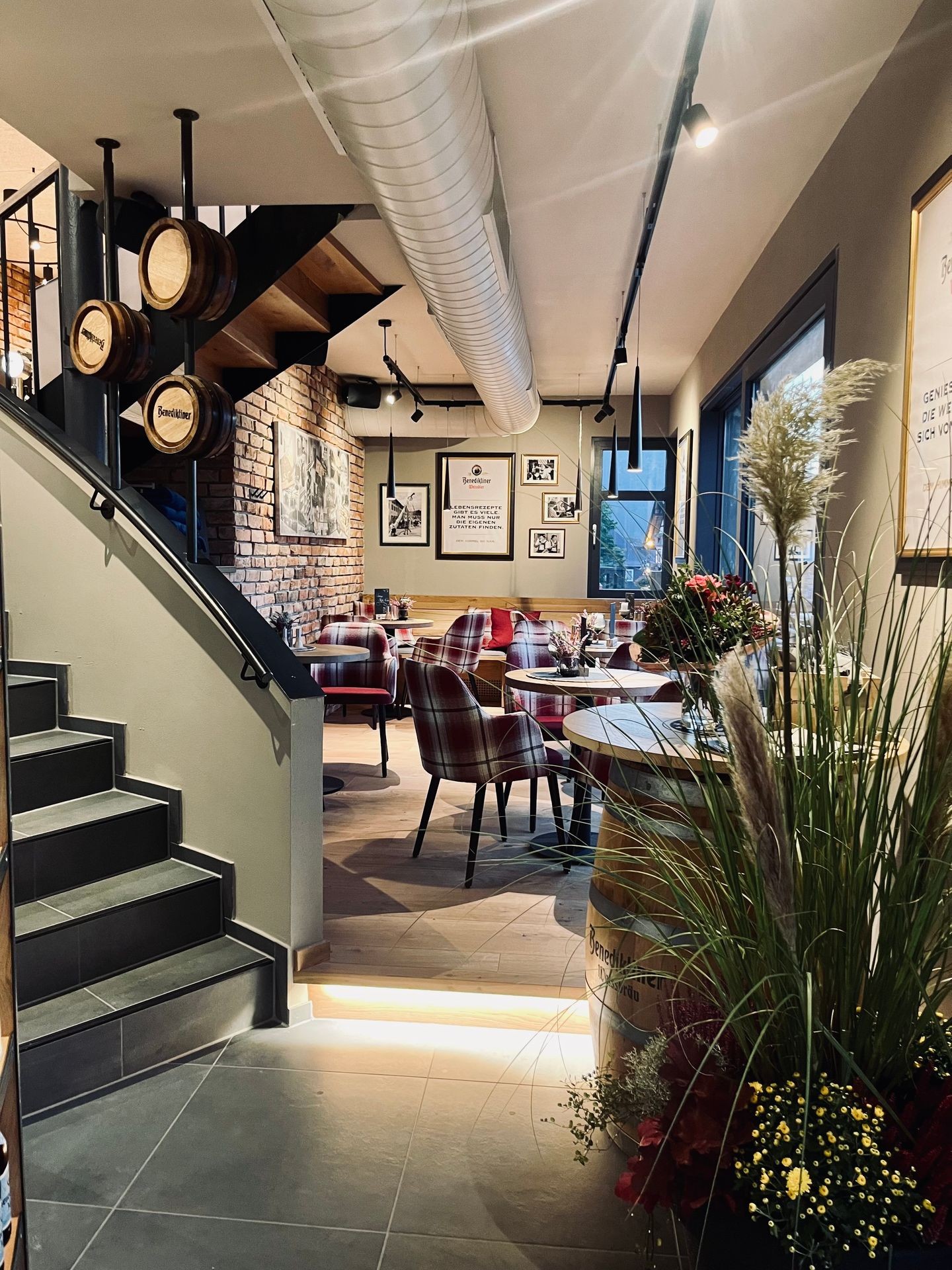 Innenaufnahme des Benediktiner Wirtshauses im Waldhaus am See. Warme Atmosphäre mit Holz, Barrique-Fässern und gemütlichen Sitzplätzen.